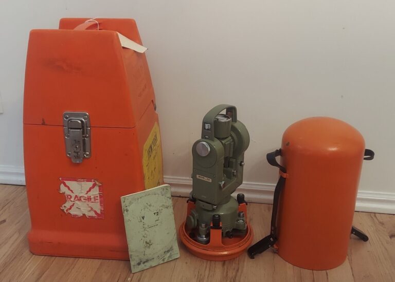 Surveying theodolite with protective cases and accessories for land measurement.