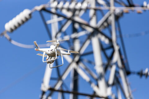 Drone capturing power line inspection for land surveying.